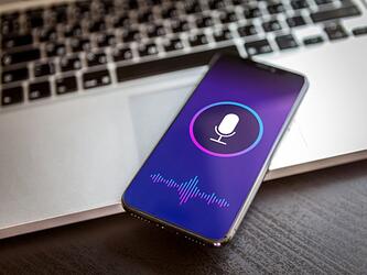 Smartphone with screen showing a microphone, voice assistant concept